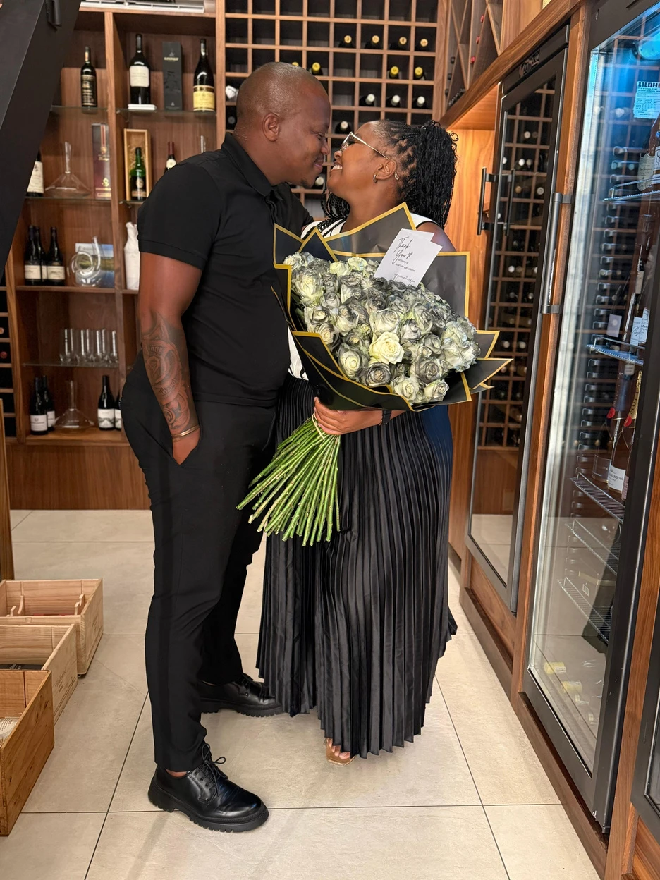 The anniversary couple celebrating together with their Grace Blooms bouquet
