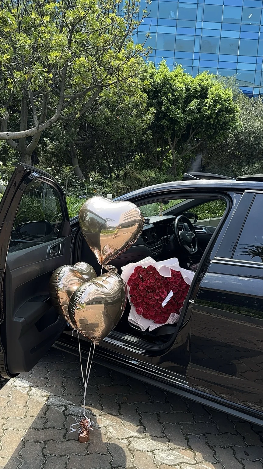 A red rose bouquet and gold heart balloons ready for a special delivery